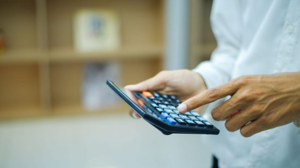 homem usando calculadora para calcular pensão alimentícia