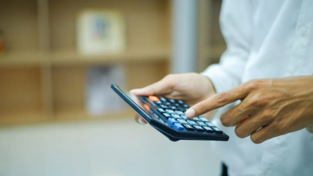 homem usando calculadora para calcular pensão alimentícia