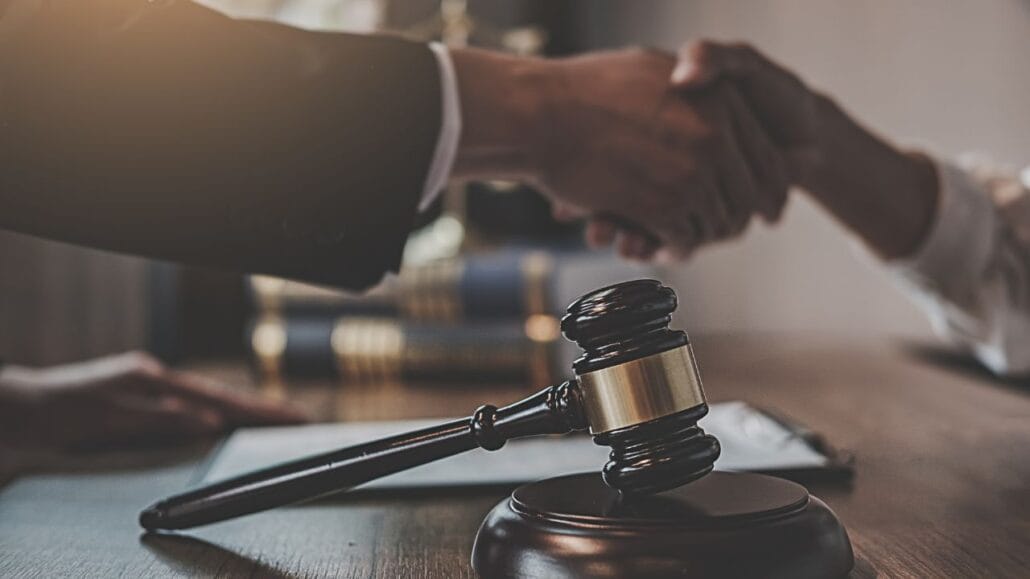 juiz e advogado dando as mãos em audiência de conciliação em divórcio litigioso