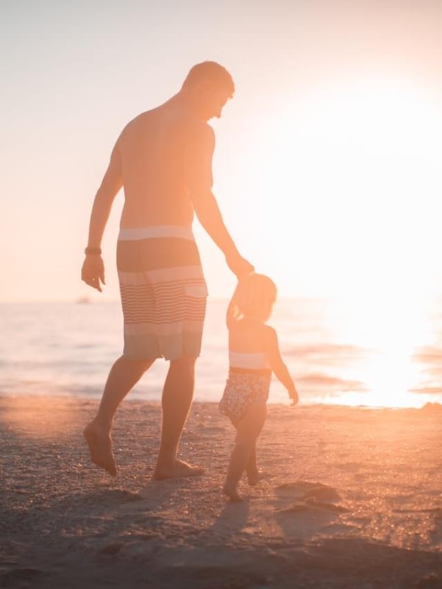 pai andando com filho na praia nos dias de visitação