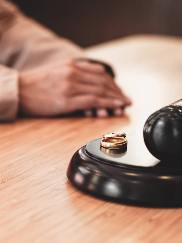 Alianças e martelo de juiz simbolizando divórcio litigioso.