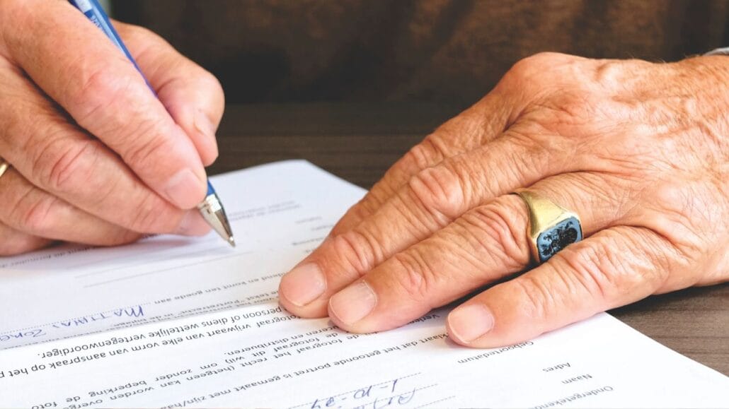 idoso assinando papeis de doação com usufruto