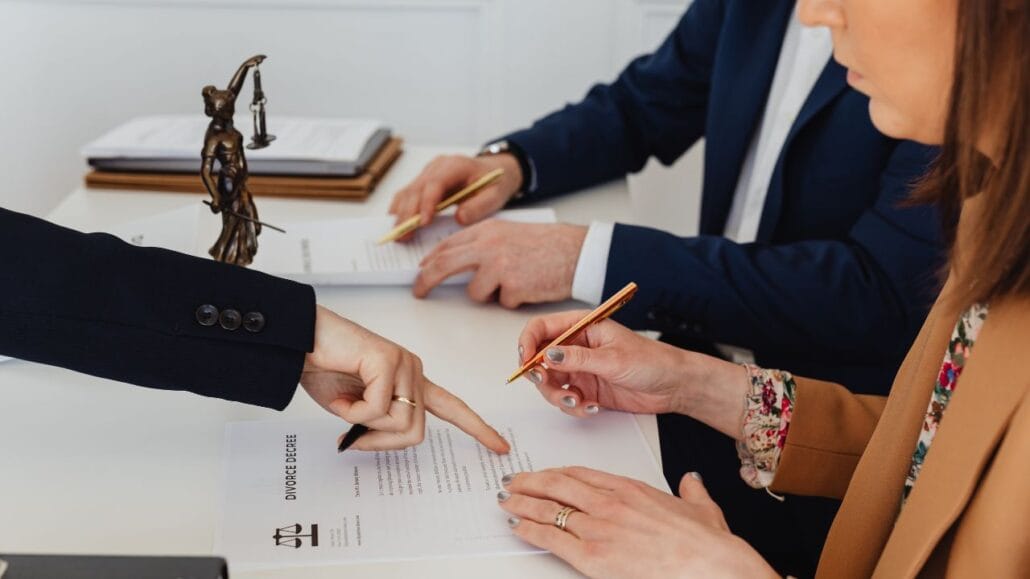 casal assinando documentos e advogado apontando