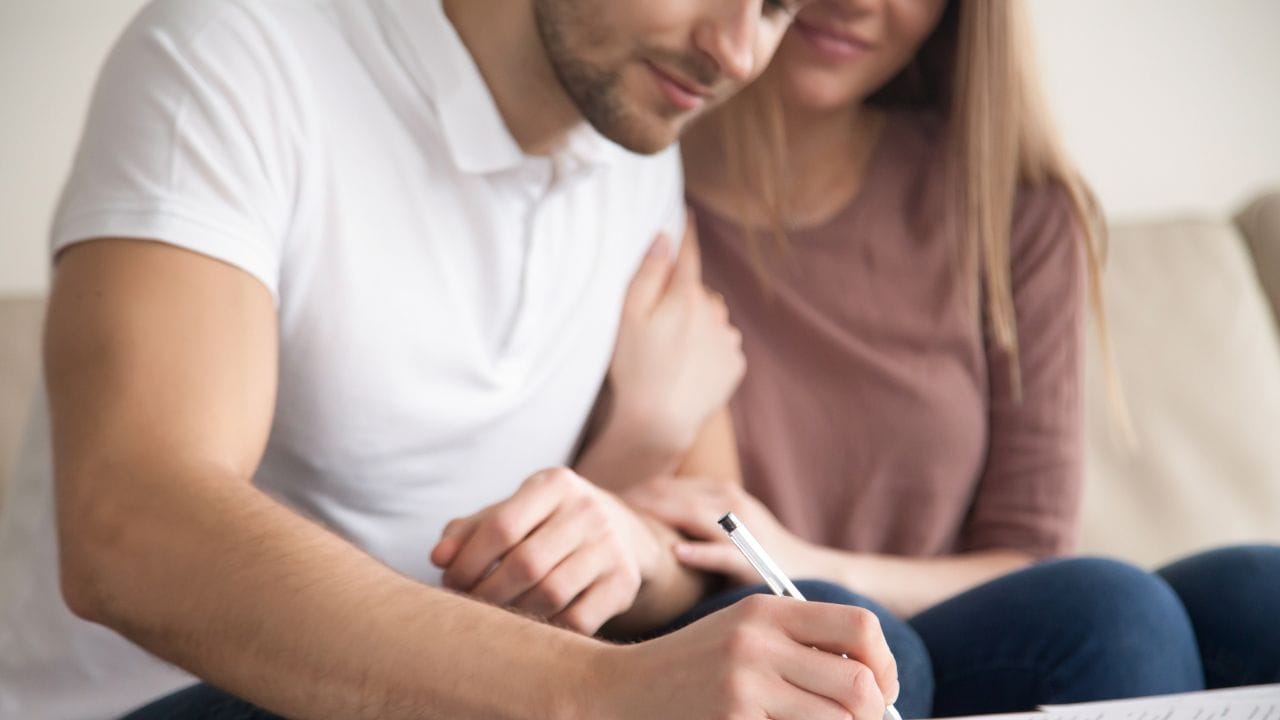 casal assinando documentos
