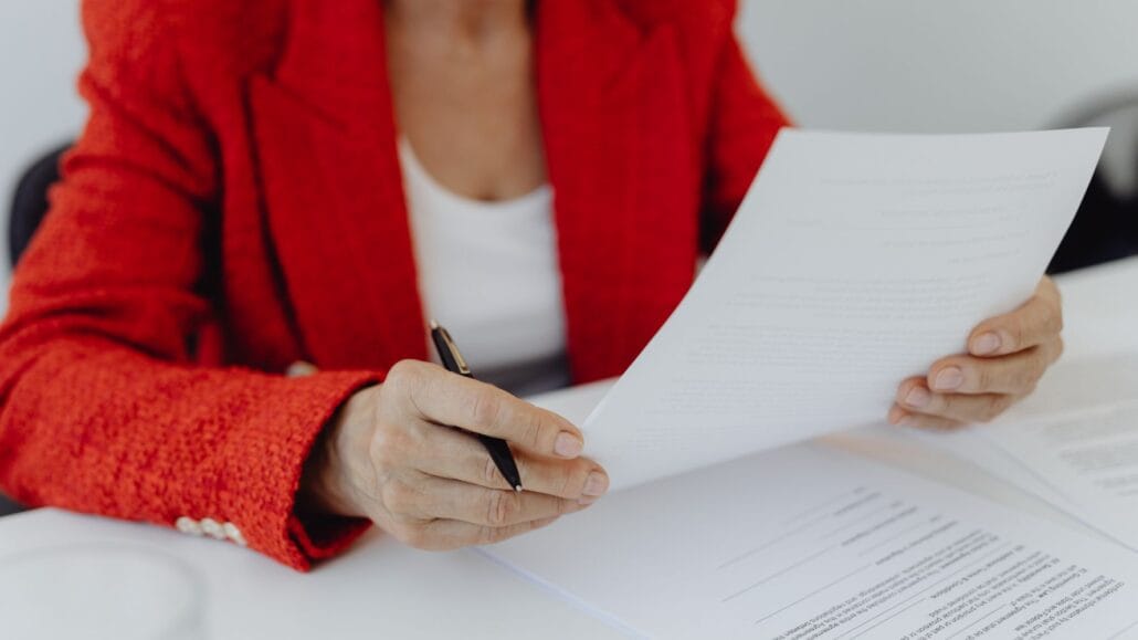 advogada de terno vermelho analisando documentos