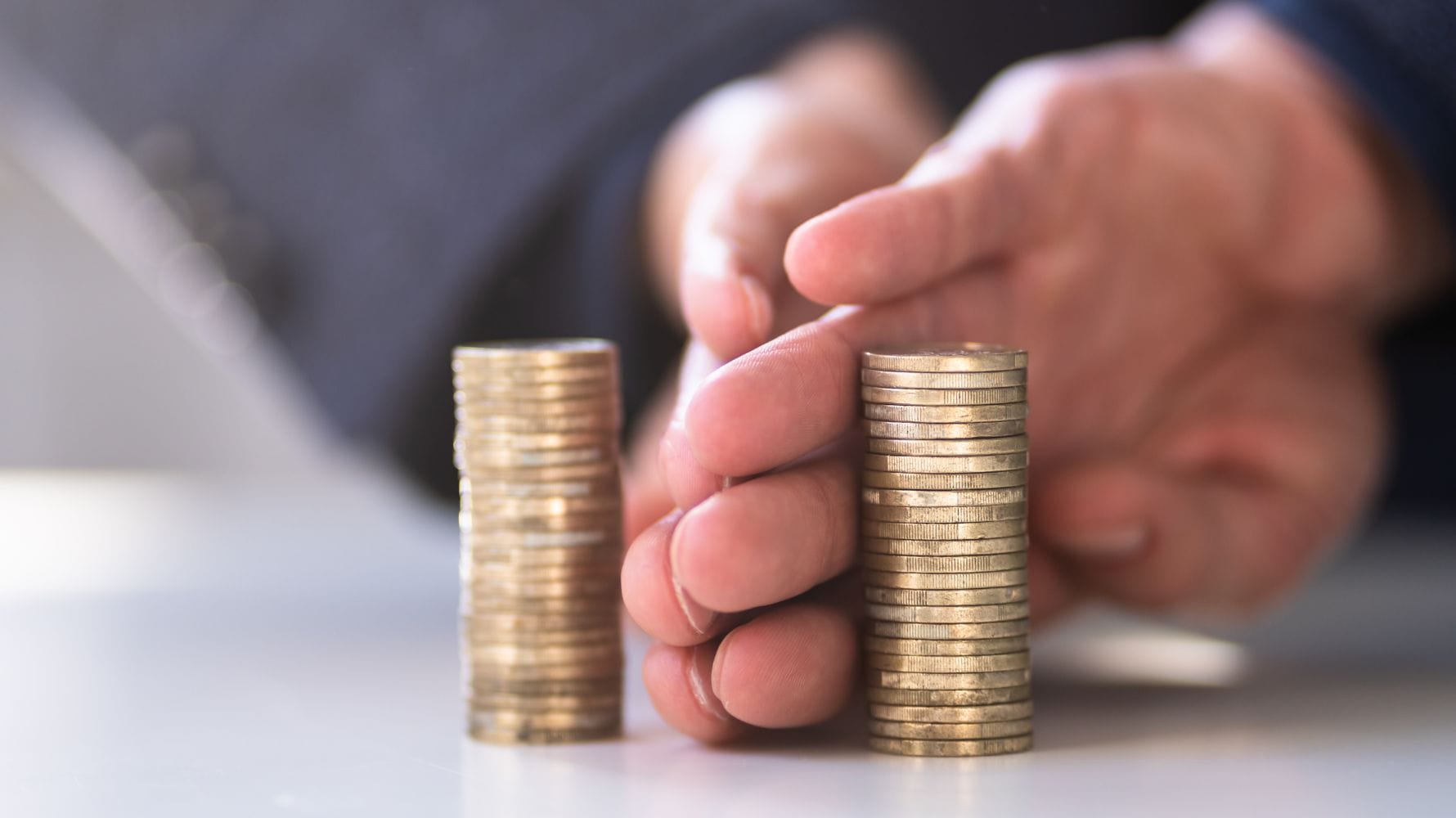 mãos separando dois aumontoados de moedas para ilustrar um post sobre regime de separação total de bens