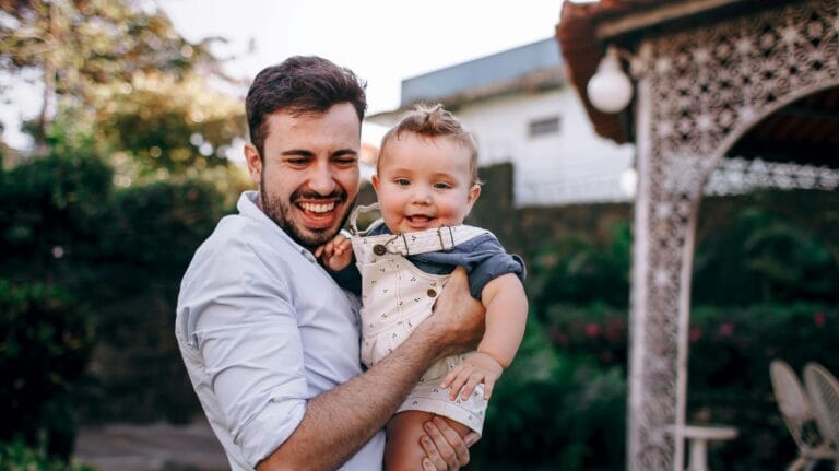 pai segurando filho no colo para ilustrar um post sobre Guarda e convivência em famílias de alta renda: