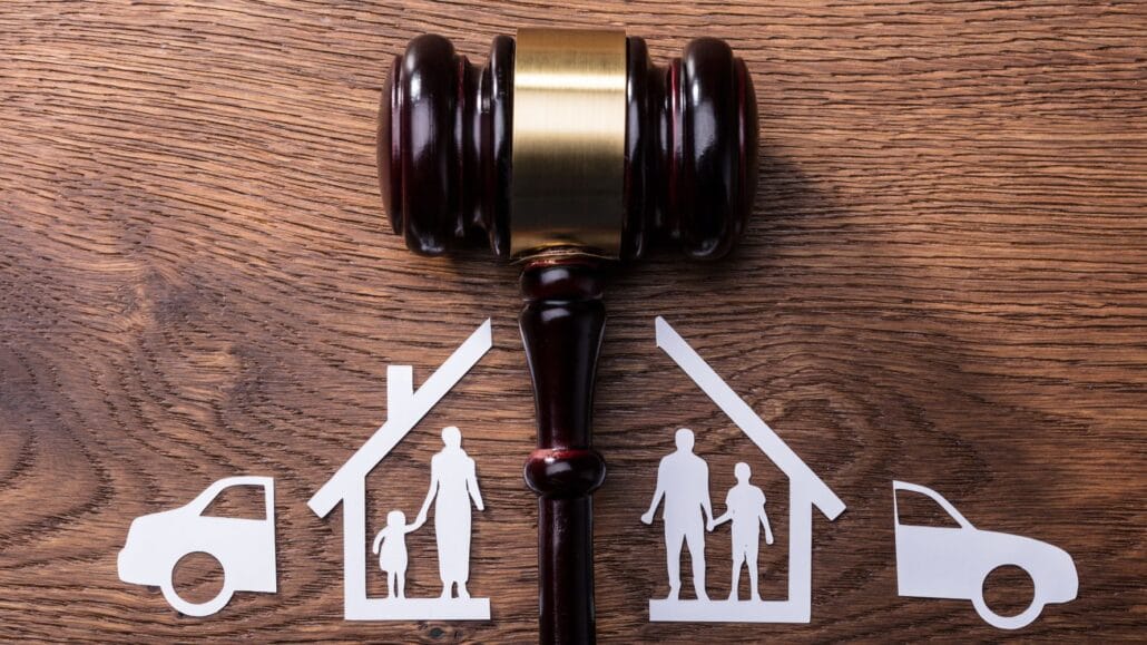 martelo de juiz no meio e desenhos de casas separadas e carros em cada lado