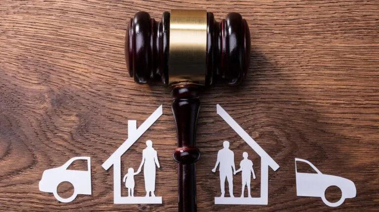 martelo de juiz no meio e desenhos de casas separadas e carros em cada lado